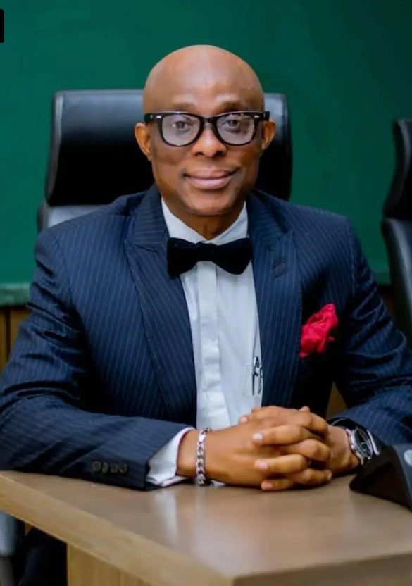 Abimbola Adeseyoju, Founder of DataPro Limited, in a navy pinstripe suit and bow tie, seated at a desk